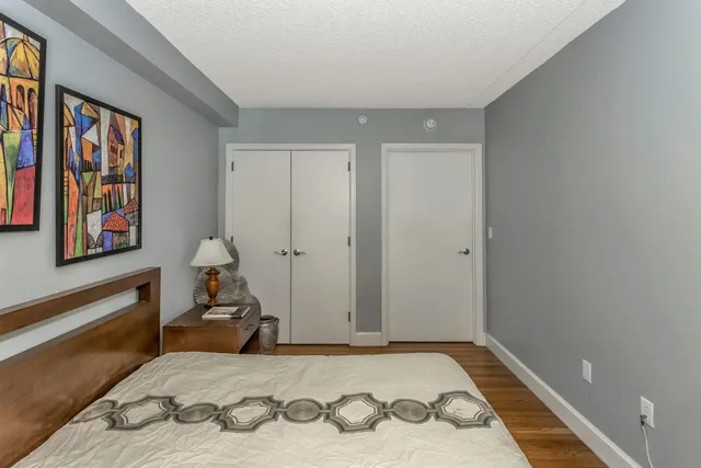 a bedroom with a bed and wooden floor