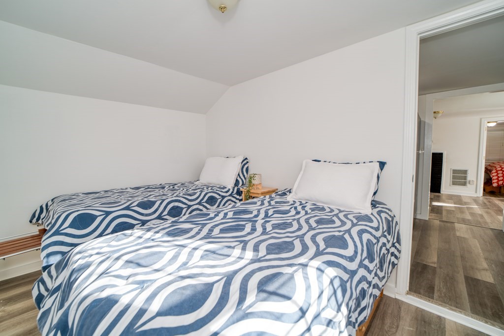 94 Sea Street, Unit B Barnstable, MA 02601 - Photo 3 of 6 a bed with a white comforter and pillows