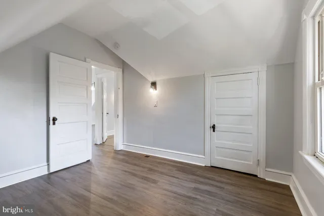a view of an empty room and wooden floor & closet area