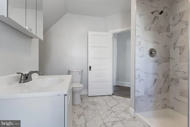 a bathroom with a sink a toilet and shower