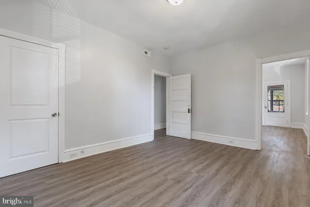 a view of an empty room with wooden floor