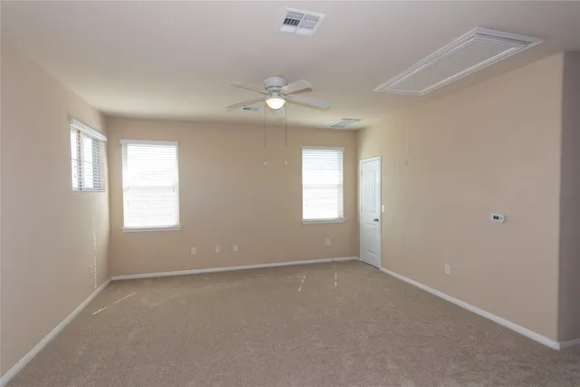 an empty room with a window and ceiling fan