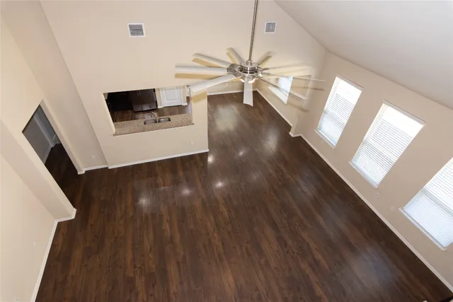 a view of a livingroom with wooden floor and a ceiling fan