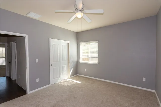 an empty room with fan and windows