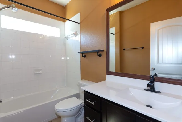 a bathroom with a sink a toilet and a large mirror