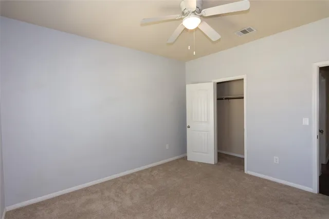 an empty room with a fan and a fan