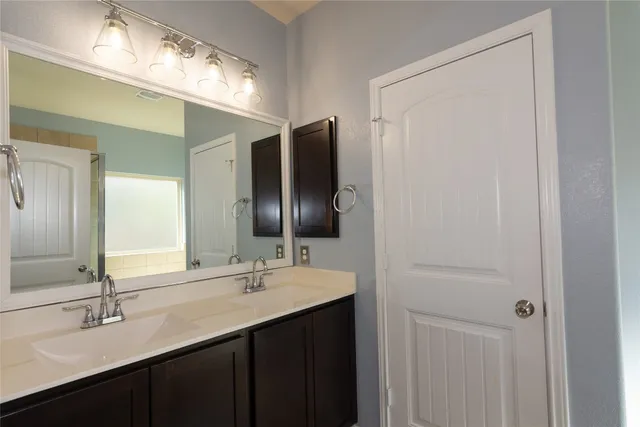 a bathroom with a double vanity sink and a mirror