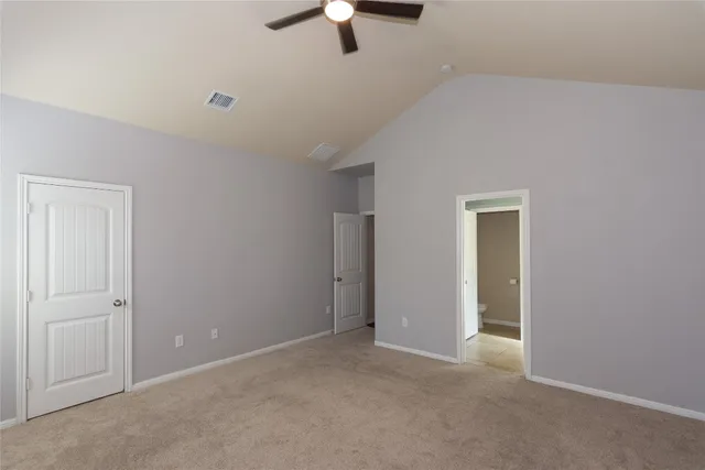 an empty room with ceiling fan and window