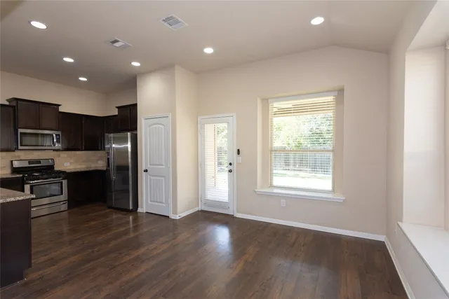 a view of kitchen with wooden floor and electronic appliances