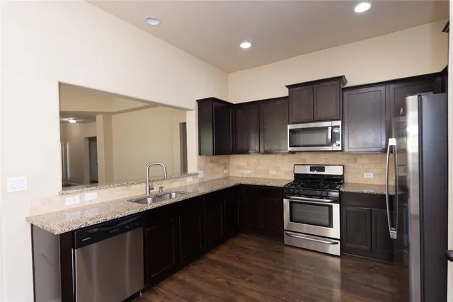 a kitchen with a sink stainless steel appliances and cabinets