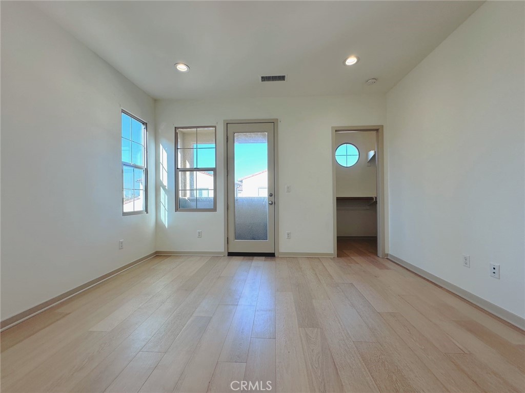 87 Evening Sun Irvine, CA 92620 - Photo 12 of 20 an empty room with wooden floor and windows