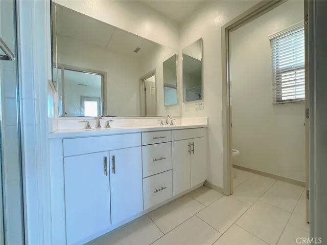 a spacious bathroom with a double vanity sink mirror and