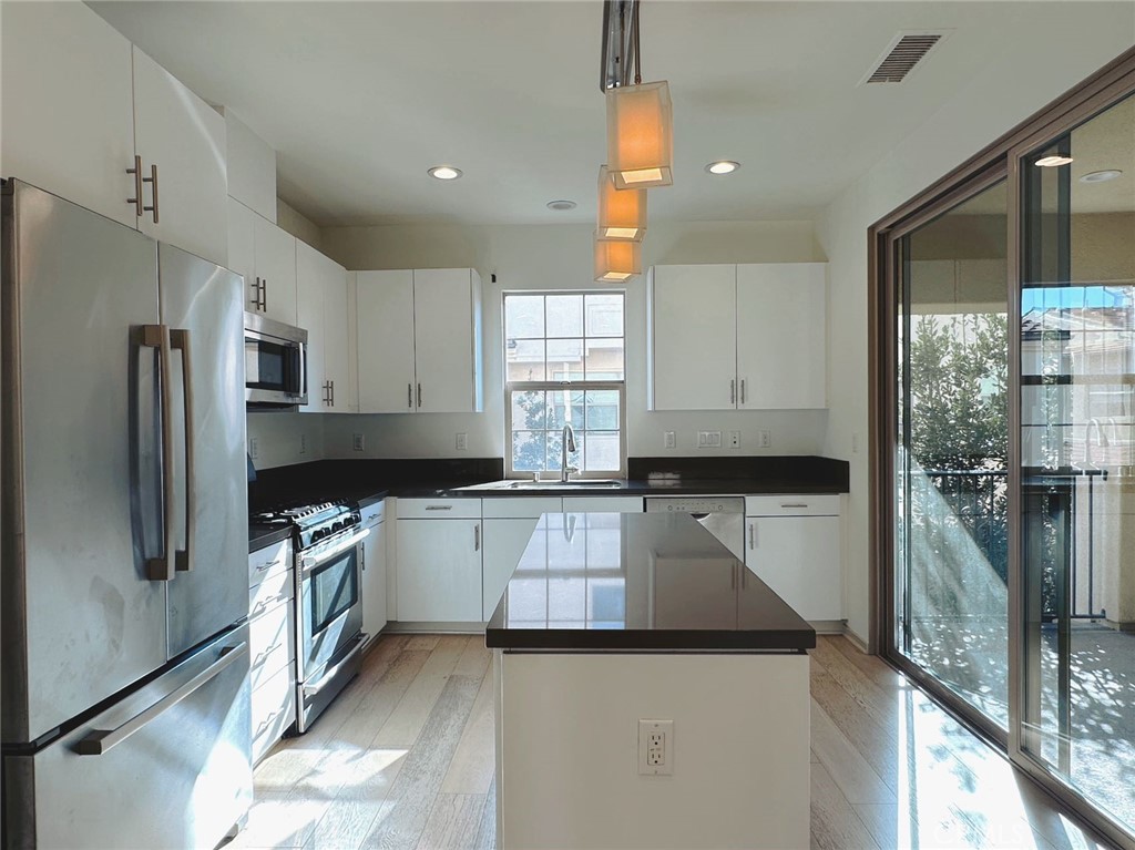 87 Evening Sun Irvine, CA 92620 - Photo 9 of 20 a kitchen with a refrigerator sink and stove