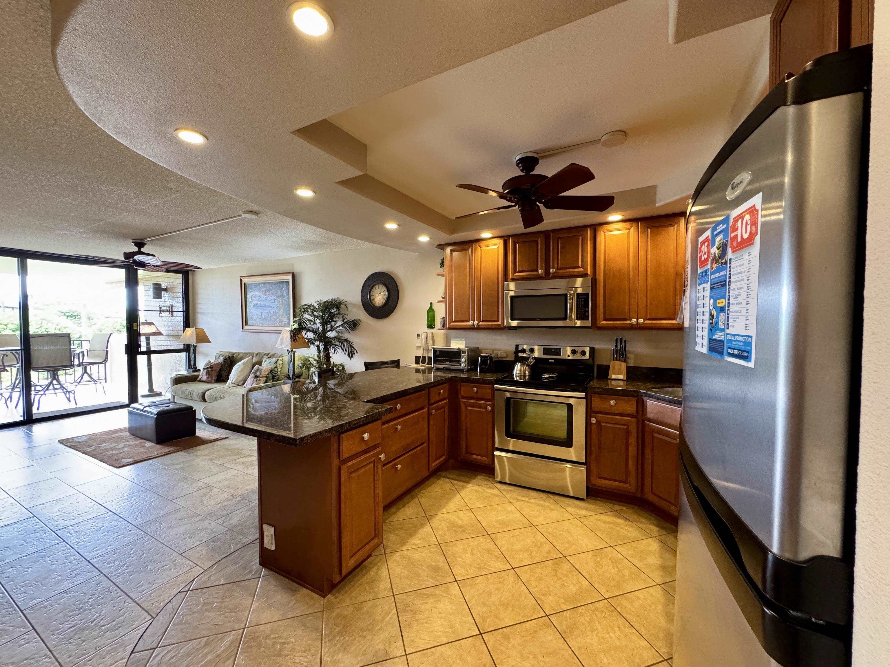 2695 South Kihei Road, Unit 10213 Kihei, HI 96753 - Photo 7 of 37 a kitchen with stainless steel appliances granite countertop a stove and a refrigerator