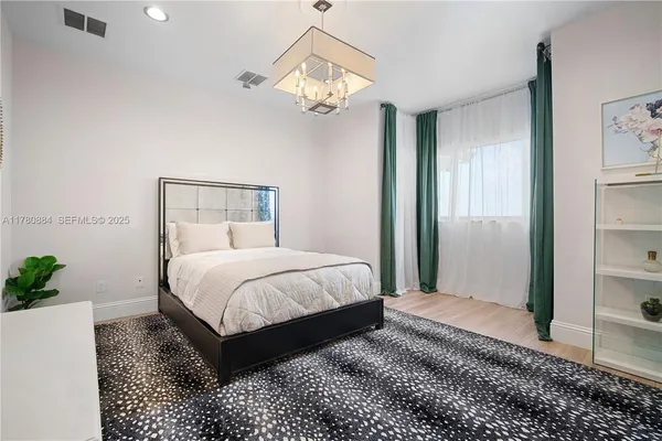 a bedroom with a bed lamp and a chandelier