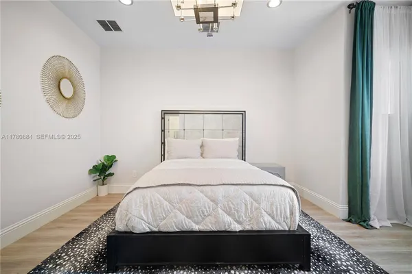 a bedroom with a bed flowerpot and window