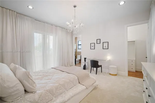 a spacious bedroom with a bed and a chandelier