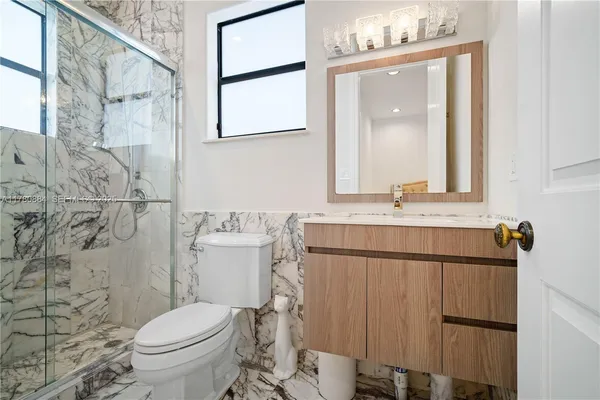 a bathroom with a sink vanity mirror and toilet