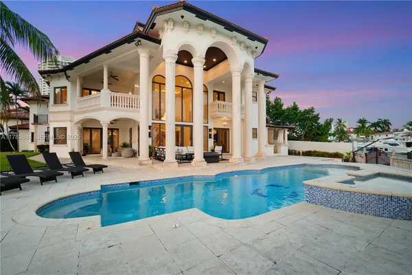 a view of a house with swimming pool and sitting area