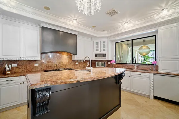 a kitchen with granite countertop a sink a counter top space and cabinets