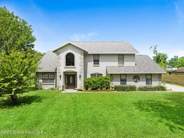a front view of a house with a garden and yard