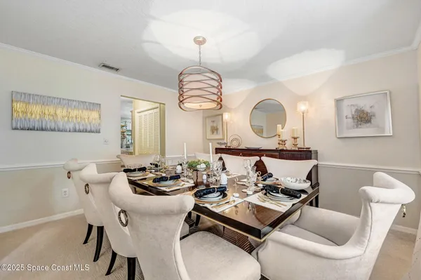 a living room with furniture a large window and a chandelier