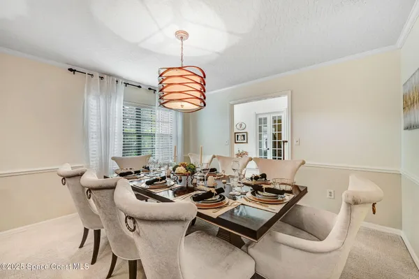 a dining room with furniture a chandelier and window