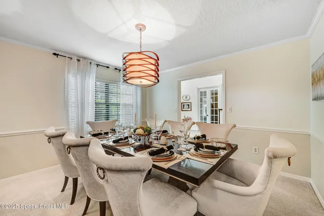 a dining room with furniture a chandelier and window