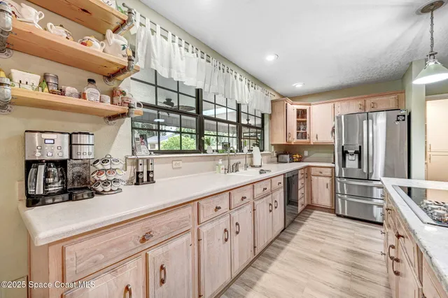 a kitchen with stainless steel appliances sink refrigerator and cabinets