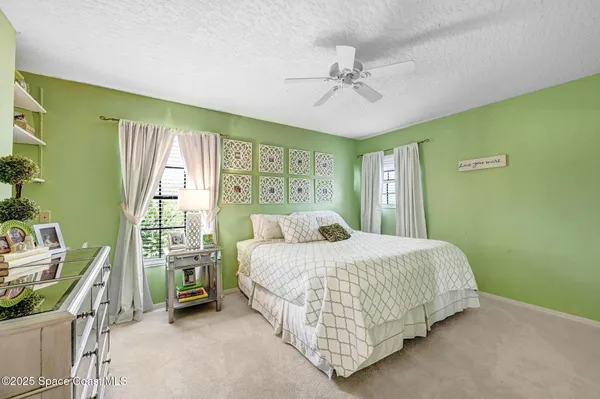 a bedroom with a bed table and chairs