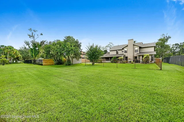 a backyard of a house with plants and large trees