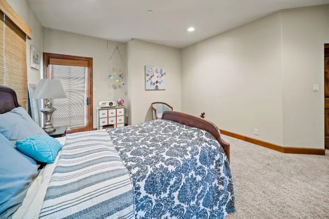 a bedroom with a bed and a dresser with wooden floor