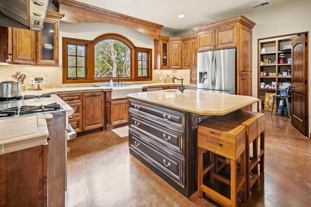a kitchen with stainless steel appliances granite countertop a refrigerator and a sink