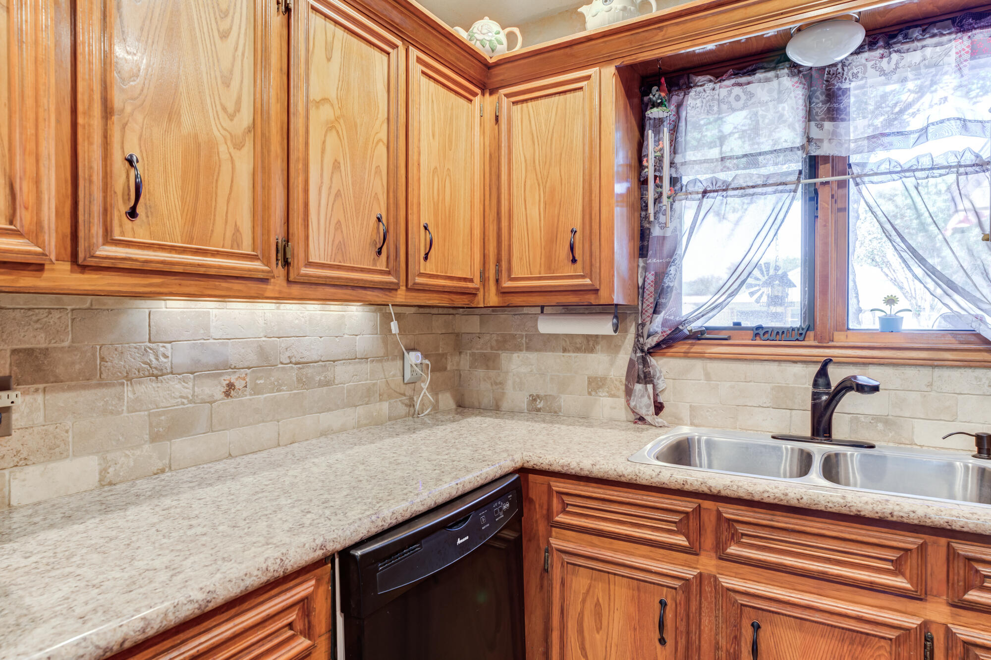 2213 86th Street Lubbock, TX 79423 - Photo 15 of 42 a kitchen with stainless steel appliances granite countertop a sink a window and cabinets
