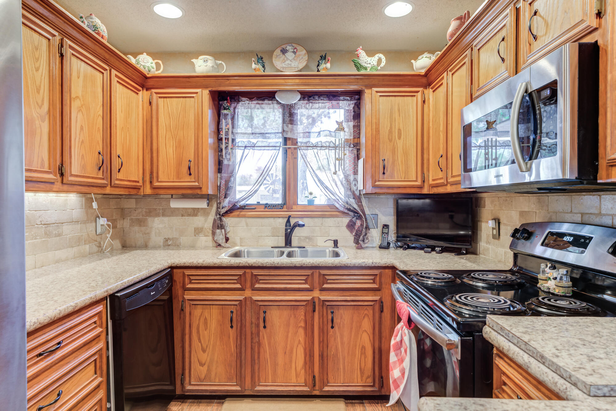 2213 86th Street Lubbock, TX 79423 - Photo 16 of 42 a kitchen with stainless steel appliances granite countertop a stove top oven a sink dishwasher and cabinets with wooden floor