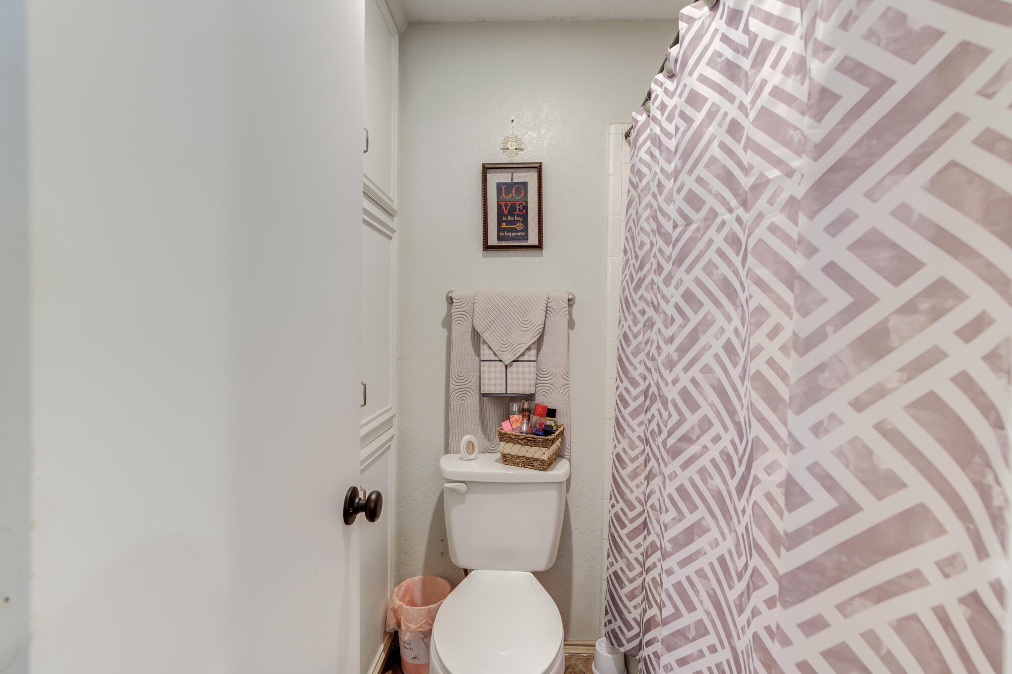 2213 86th Street Lubbock, TX 79423 - Photo 27 of 42 a white toilet sitting next to a shower curtain