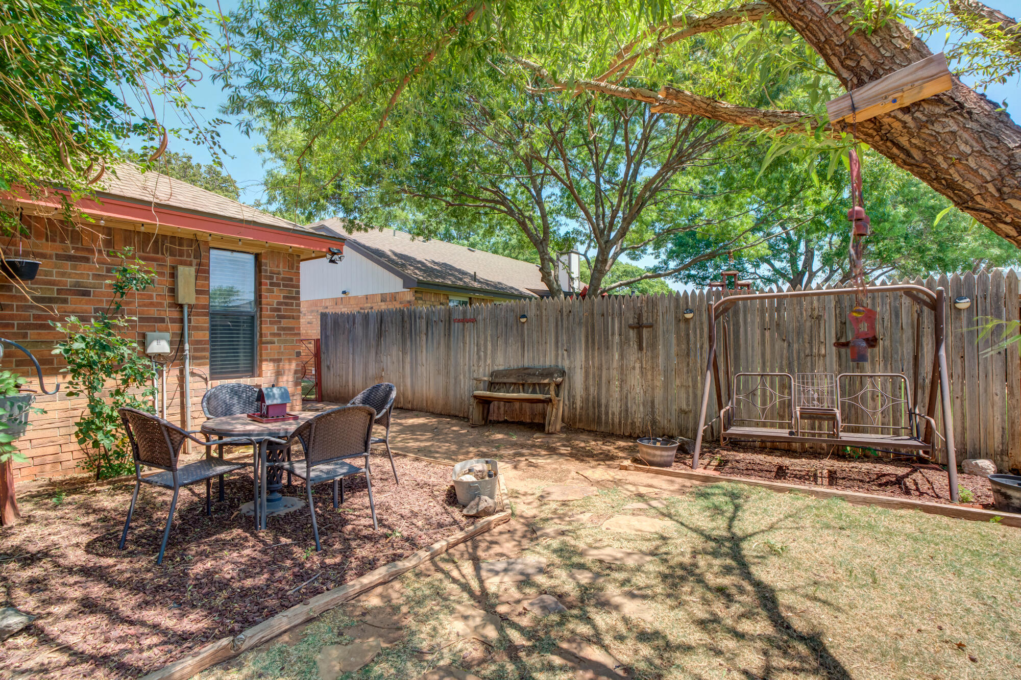 2213 86th Street Lubbock, TX 79423 - Photo 36 of 42 a view of backyard with a table and chairs and wooden fence