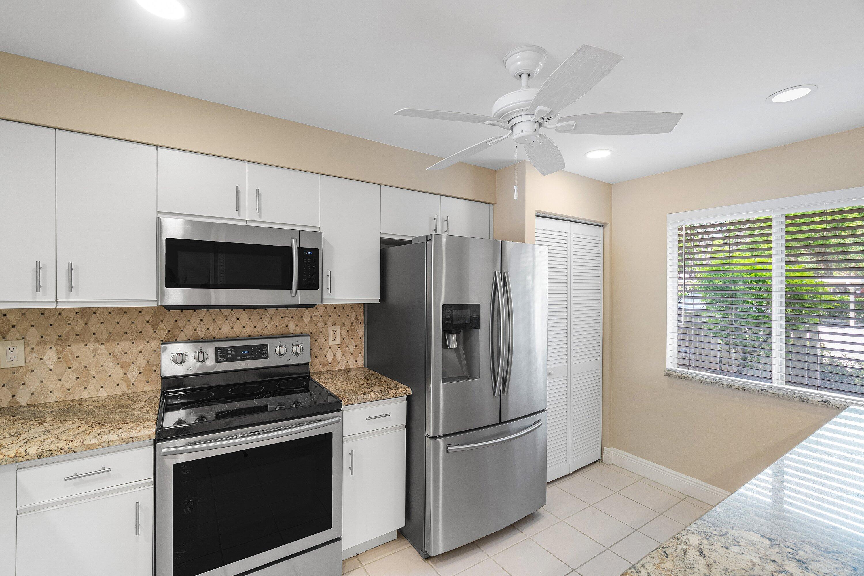 14096 Huntington Pointe Drive, Unit 106 Delray Beach, FL 33484 - Photo 20 of 47 a kitchen with stainless steel appliances granite countertop a refrigerator oven stove a sink and dishwasher