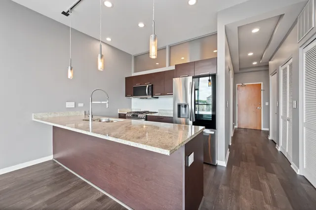 a large kitchen with stainless steel appliances lots of counter space and a sink