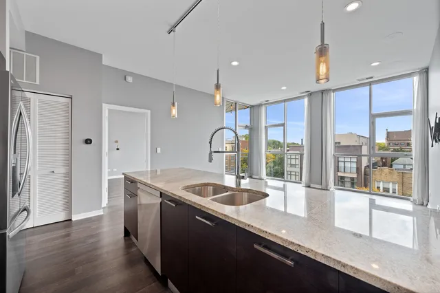 a kitchen with stainless steel appliances granite countertop a sink a stove and a refrigerator