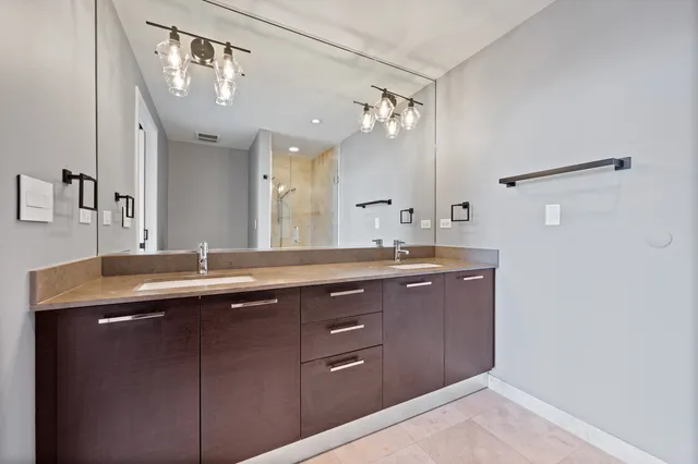 a bathroom with a granite countertop sink a mirror and shower