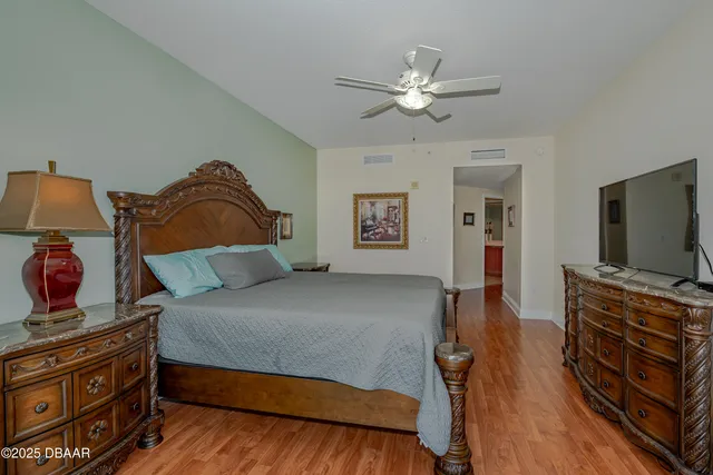 a bedroom with a bed and a flat tv screen on dresser