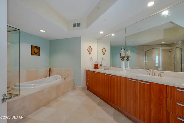 a bathroom with a tub a sink double vanity and a mirror