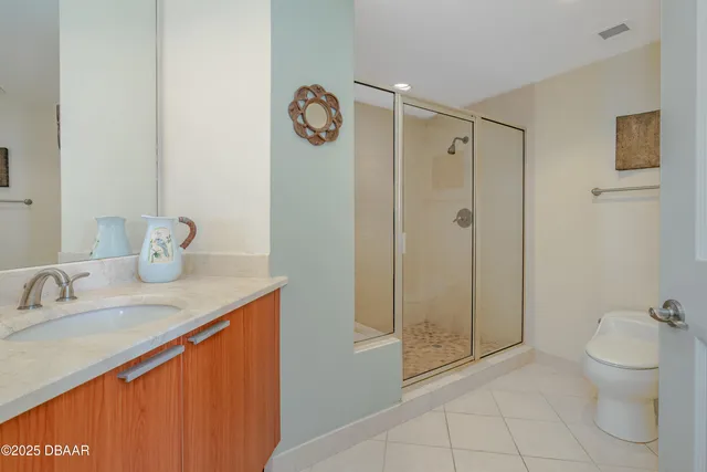 a bathroom with a granite countertop sink a toilet and shower