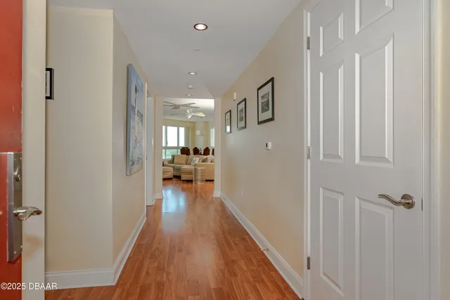 a view of a hallway with wooden floor and furniture
