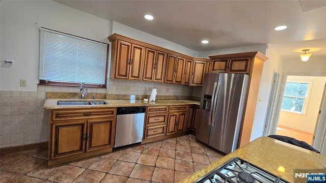 a kitchen with stainless steel appliances granite countertop a refrigerator and a stove top oven