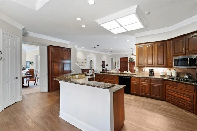 a kitchen with granite countertop a sink stainless steel appliances and cabinets