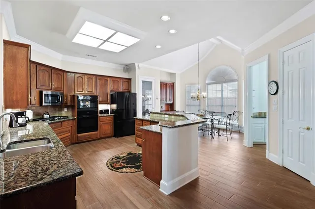 a kitchen with stainless steel appliances granite countertop a stove refrigerator and cabinets