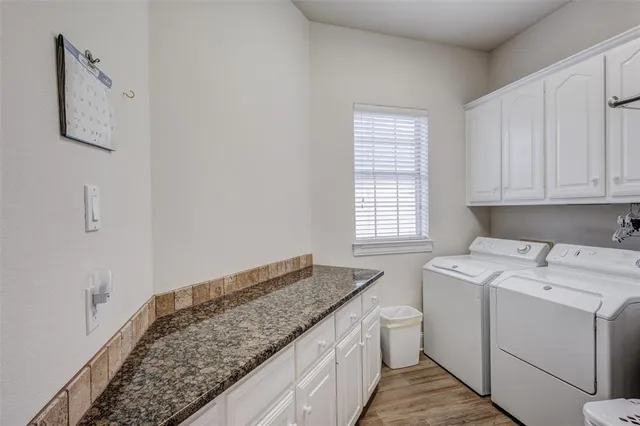 a kitchen with granite countertop wooden cabinets and refrigerator
