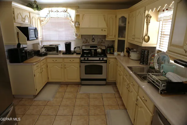 a kitchen with stainless steel appliances granite countertop a stove a sink and a microwave